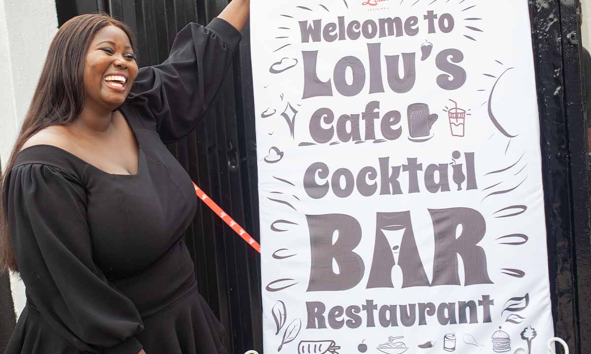 lady holding up lolu's cafe sign